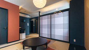 Una habitación japonesa tradicional con suelo de tatami, una mesa baja y paneles shoji.