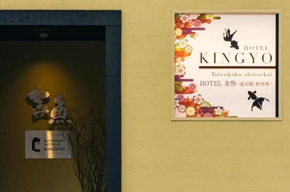 A hotel sign with the name 'HOTEL KINGYO' and a decorative floral design.