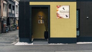 Entrada de hotel con un cartel que dice 'KINGYO HOTEL' y una estética japonesa tradicional.