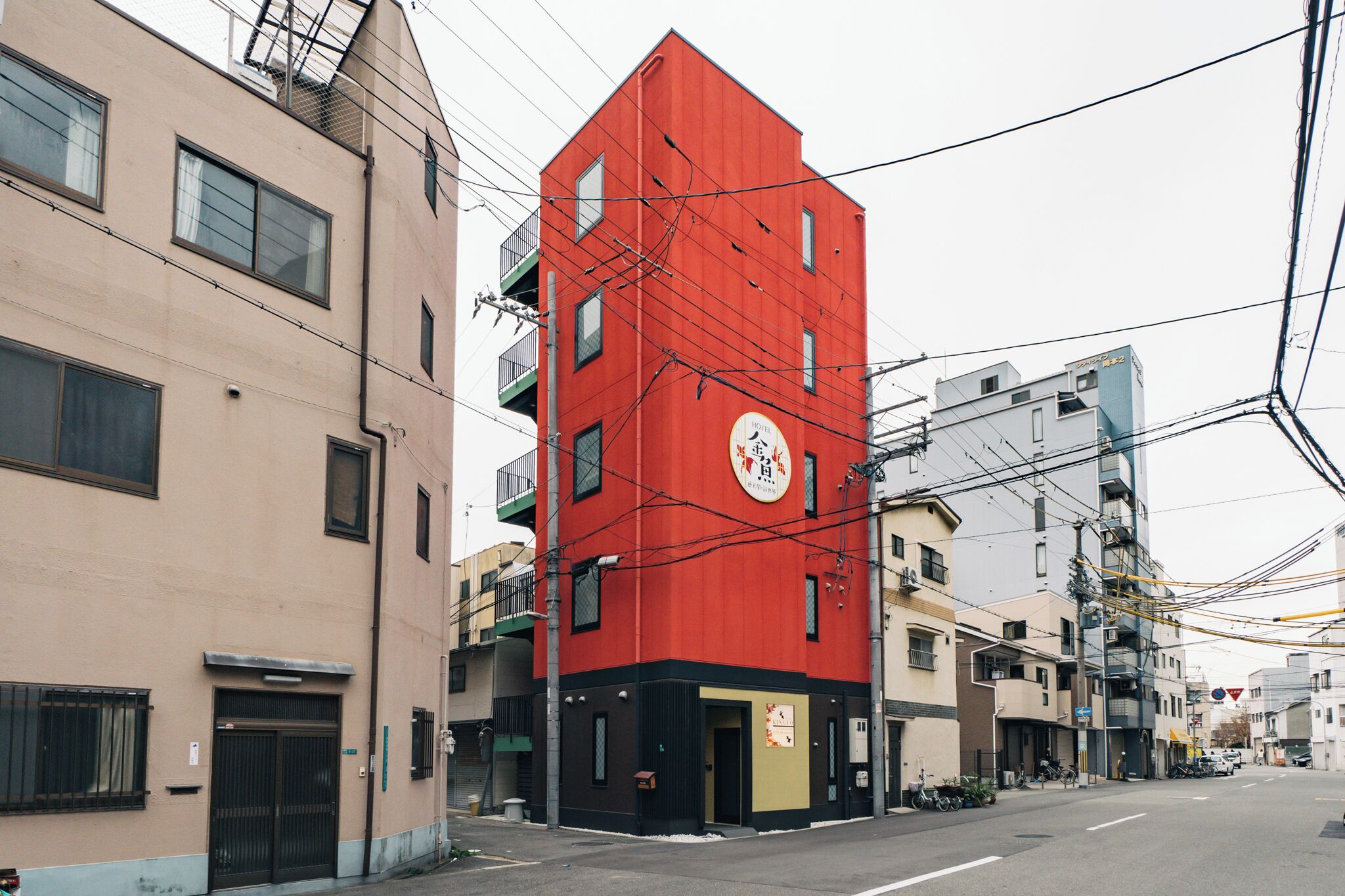 Un immeuble à plusieurs étages, doté d’une façade rouge, de nombreuses fenêtres et de balcons.