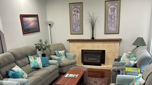 A living room with a fireplace, two sofas, a coffee table, and a rug. - Kelly's House excellent for contractors, families and pets (Bunbury)