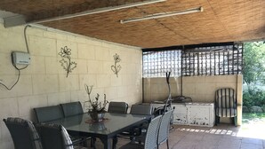An outdoor patio with a table and chairs, a grill, and a decorative wall. - Kelly's House excellent for contractors, families and pets (Bunbury)