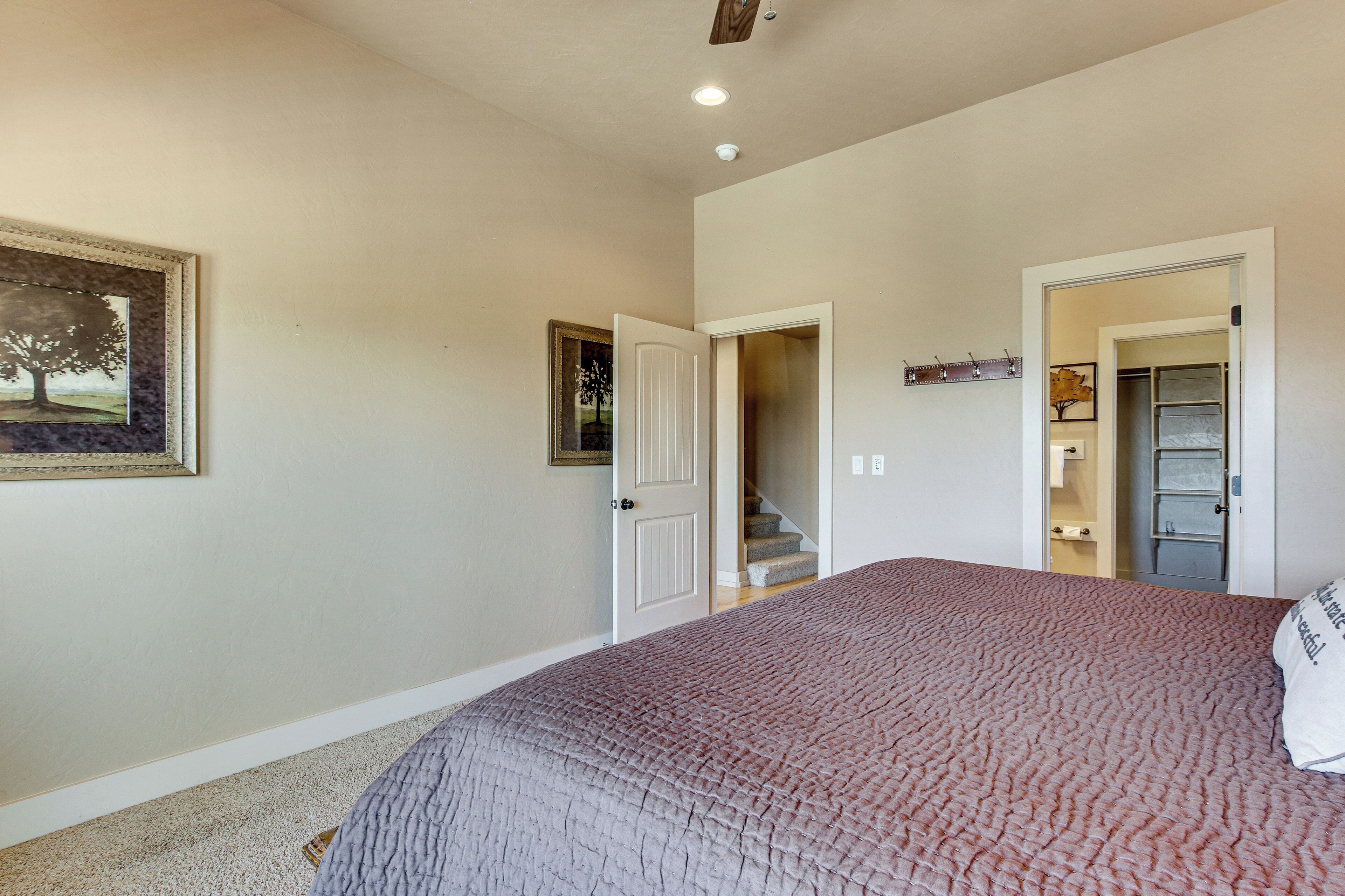 Une chambre à coucher avec un lit, une porte, un escalier et un couloir.