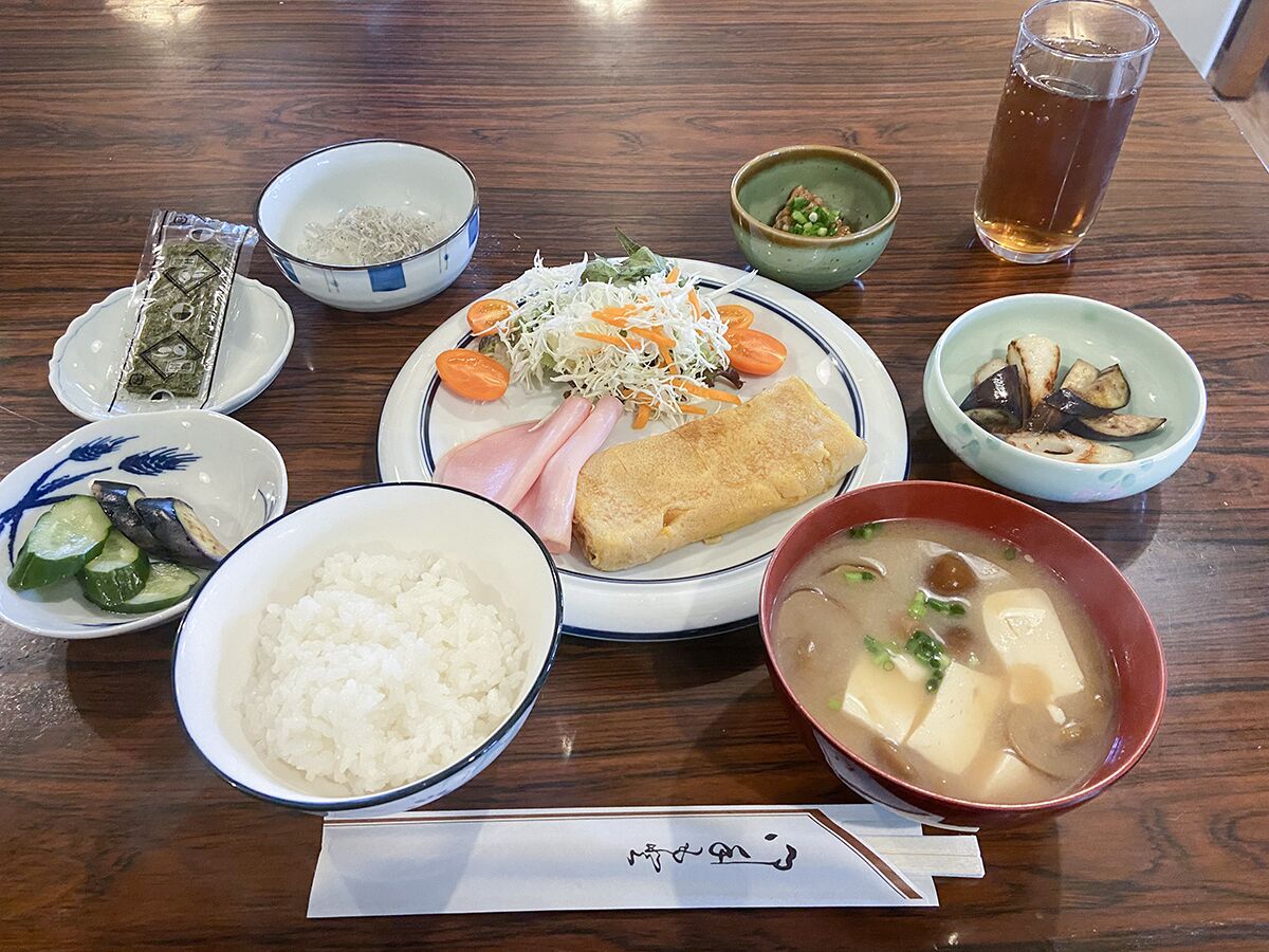 A table with various dishes including rice, soup, and a plate with vegetables and meat.