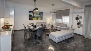 A modern living space with a dining area, sofa, and ottoman. - Unique Apartment near Acropolis by GHH (Athens)