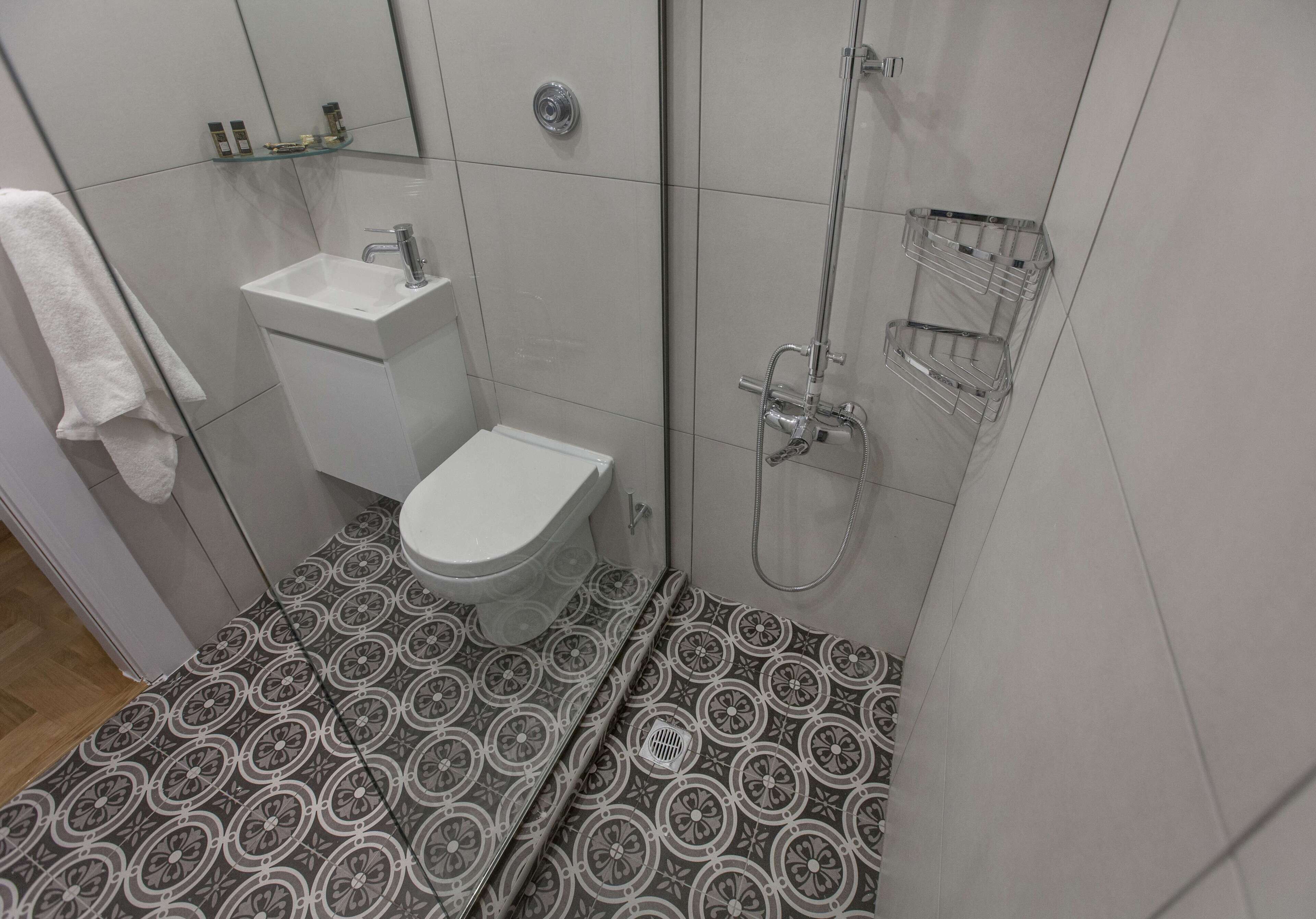 Une salle de bain avec des toilettes, un lavabo et une douche.