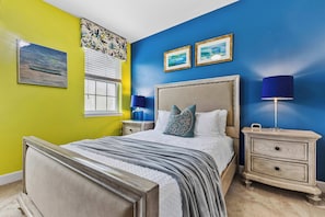 A bedroom with a bed, nightstands, a lamp, and artwork on the walls. - Bright 3B/2.5B townhome at Enclaves at Festival, minutes from Disney & Champions Gate. Private pool, resort amenities, sleeps 8. (Davenport)