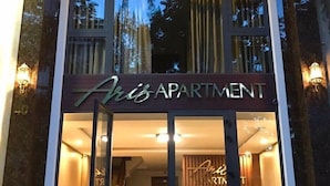 Entrada de un moderno edificio de apartamentos con un letrero que dice "Aria Apartment".