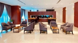 A modern hotel lobby with a reception desk, seating area with armchairs, and a bar. - The View Serviced Residence (Phnom Penh)