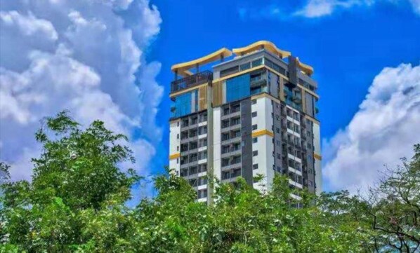 A multi-story building with a modern architectural design, featuring balconies and large windows.