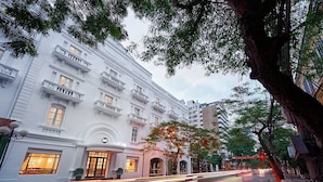 A multi-story hotel with a classic architectural style, featuring balconies and large windows.