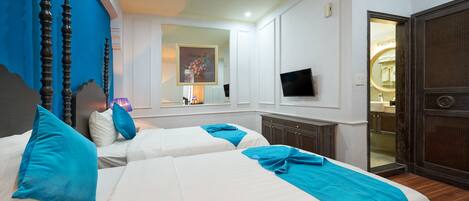 A hotel room with two beds, a TV, and a mirror.
