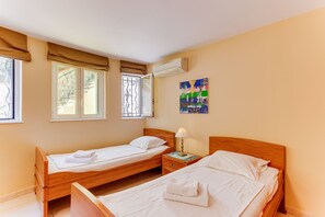 A hotel room with two single beds, a nightstand with a lamp, and a painting on the wall. - LA MALMAISON AP1064 by RIVIERA HOLIDAY HOMES (Villefranche-sur-Mer)