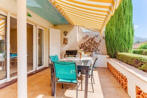 A patio with a table and chairs, a grill, and a decorative wall. - LA MALMAISON AP1064 by RIVIERA HOLIDAY HOMES (Villefranche-sur-Mer)
