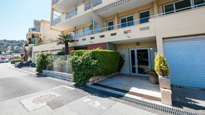 A multi-story residential building with balconies, a gated entrance, and a garage. - VILLA HENRIETTA AP4070 by RIVIERA HOLIDAY HOMES (Villefranche-sur-Mer)