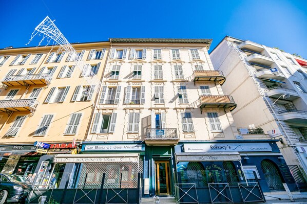 A multi-story building with a variety of shops on the ground floor, including a restaurant and a bar. - CARRE D' OR TERRACE AP4015 by RIVIERA HOLIDAY HOME (Niza)