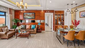 A modern living room with a sofa set, coffee table, and dining area with chairs and a table.