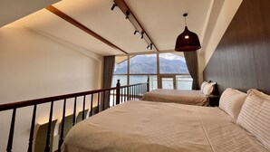 A bedroom with a large bed, a view of mountains, and a balcony with a railing. - Ming Hu B&B (No elevator) (Yuchi)