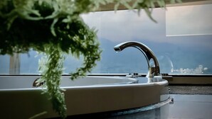 A bathroom with a sink, a window, and a view of a cityscape. - Ming Hu B&B (No elevator) (Yuchi)