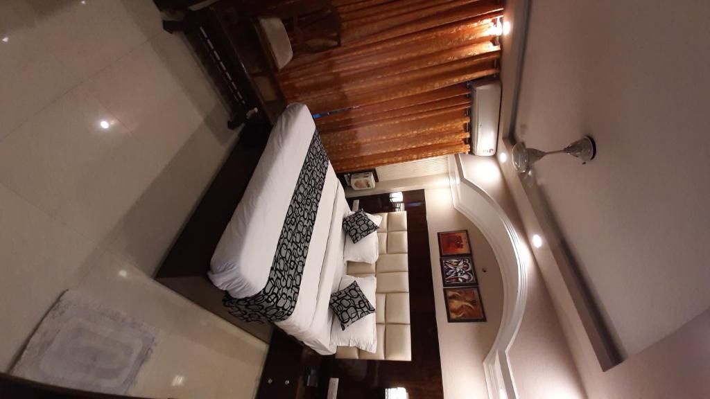 Una camera da letto con un letto, un comodino, una lampada e un'opera d'arte appesa al muro.
