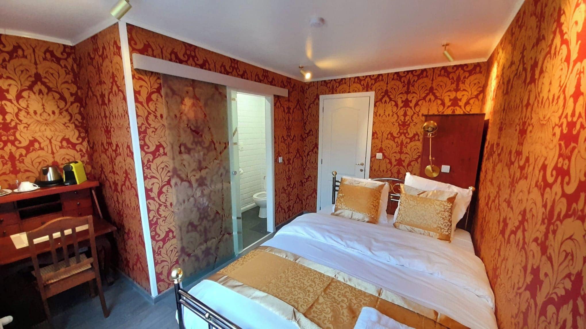 Une chambre d’hôtel avec un lit, un bureau et une armoire.