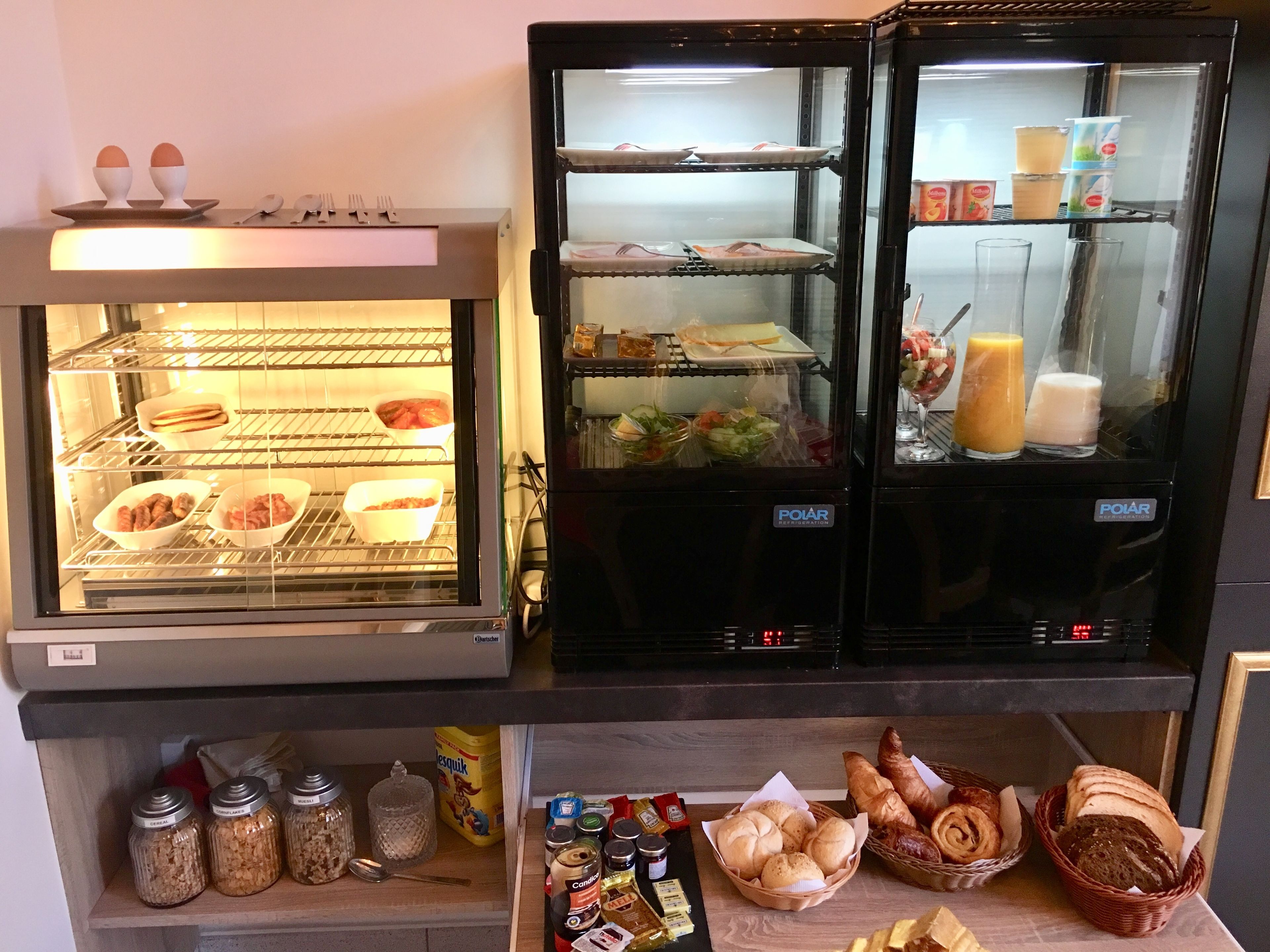 Una vitrina de pastelería con diferentes productos horneados y salsas.
