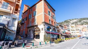 Un edificio de varios pisos con balcones y un restaurante en la planta baja.