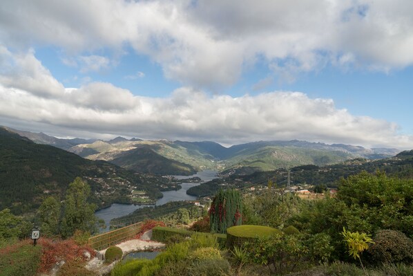 A panoramic view of a mountainous landscape with a lake and a small village.