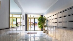 A hallway with a marble floor, a potted plant, and a row of mailboxes. - LE FRANCE-MASSENET AP3015 by RIVIERA HOLIDAY HOMES (Niza)