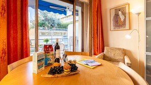 A dining table with a bottle of wine, a box, and a tray of grapes. - LE FRANCE-MASSENET AP3015 by RIVIERA HOLIDAY HOMES (Niza)