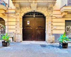 A double wooden door with a 'No Parking' sign, flanked by stone pillars and potted plants. - Bellaroto Suite & Spa - Charming Boutique Rooms (Palermo)