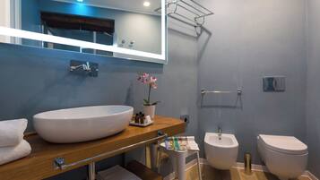 Un bagno moderno con un lavandino bianco capiente, un bidet e un water.
