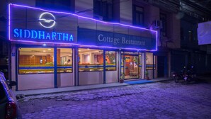 A building with a sign reading "SIDDHARTHA Cottage Restaurant" and a neon sign above. - Siddhartha Cottage Butwal (Butwal)
