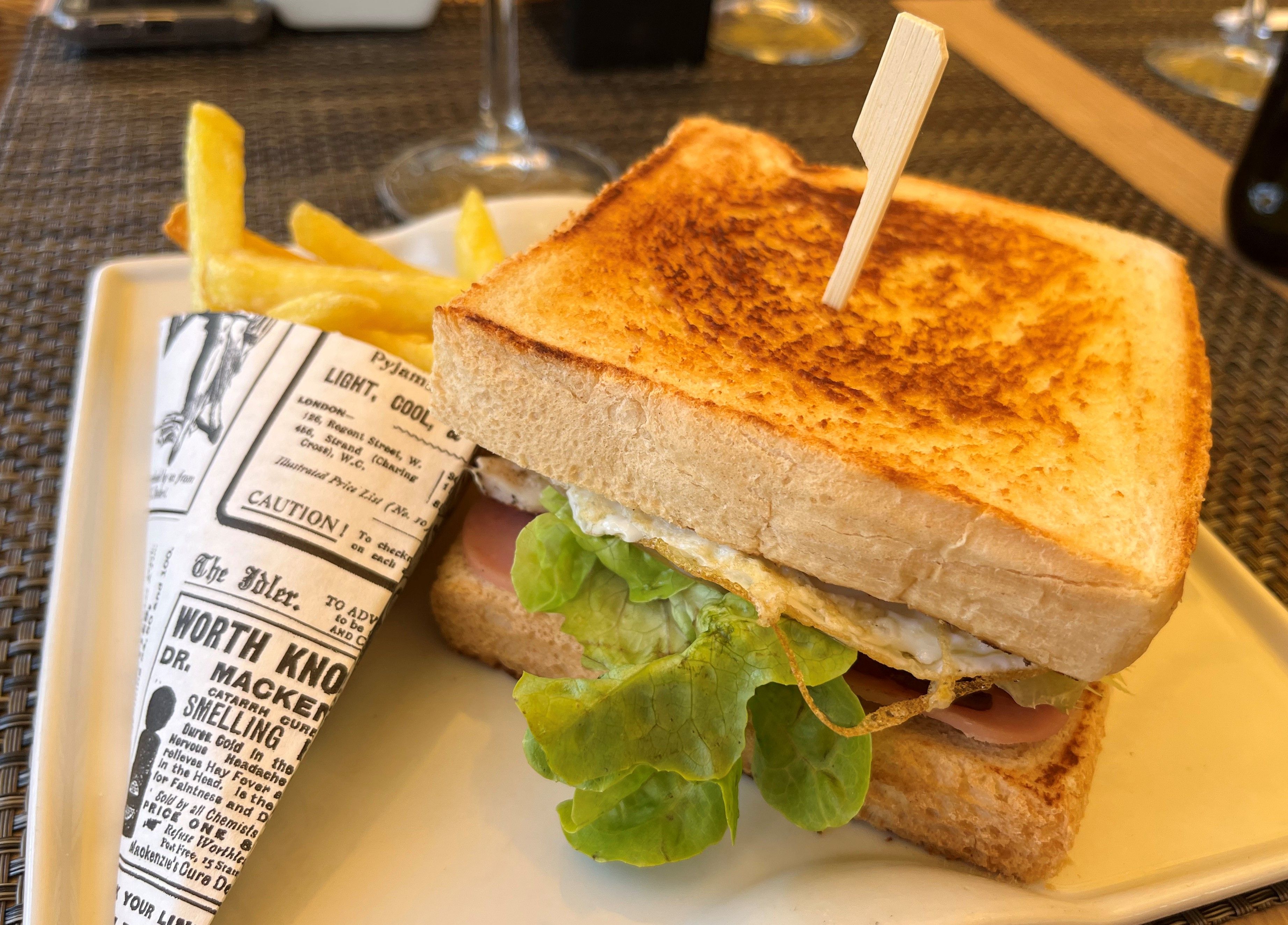 Un sandwich à la laitue, accompagné d’une portion de frites, servi sur une assiette.