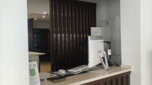 Mostrador de recepción con computadora, teléfono y un cartel que anuncia un 5% de descuento en servicios médicos.