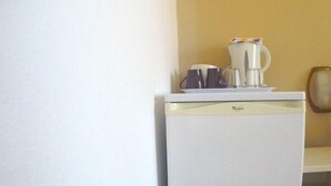 A compact white refrigerator with a small shelf and a coffee maker on top. - Vila Lacman (Hvar)