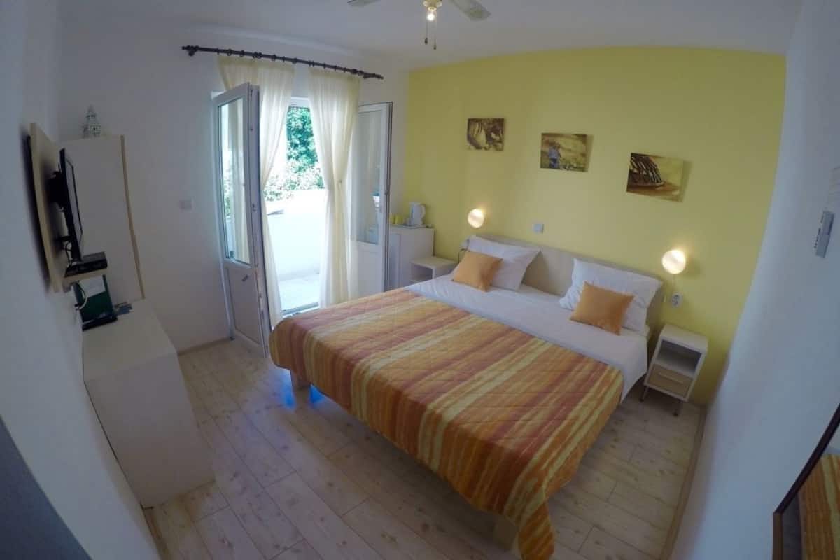 A bedroom with a bed, bedside tables, and a window with curtains.