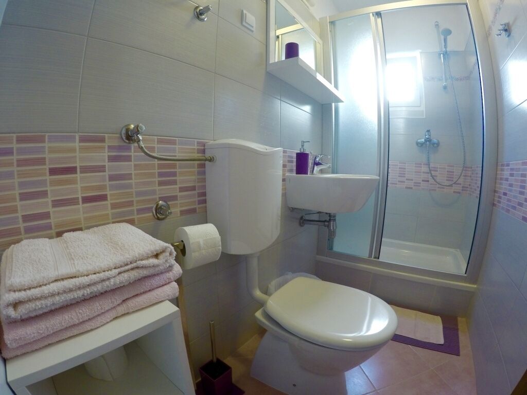 A bathroom with a toilet, sink, and shower.