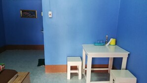 A room with blue walls, a white table, and two white stools.