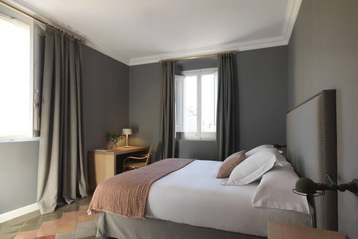 Une chambre à coucher avec un lit, un bureau et une fenêtre.