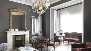 Amplia sala de estar con chimenea, un candelabro elegante y un espejo grande.