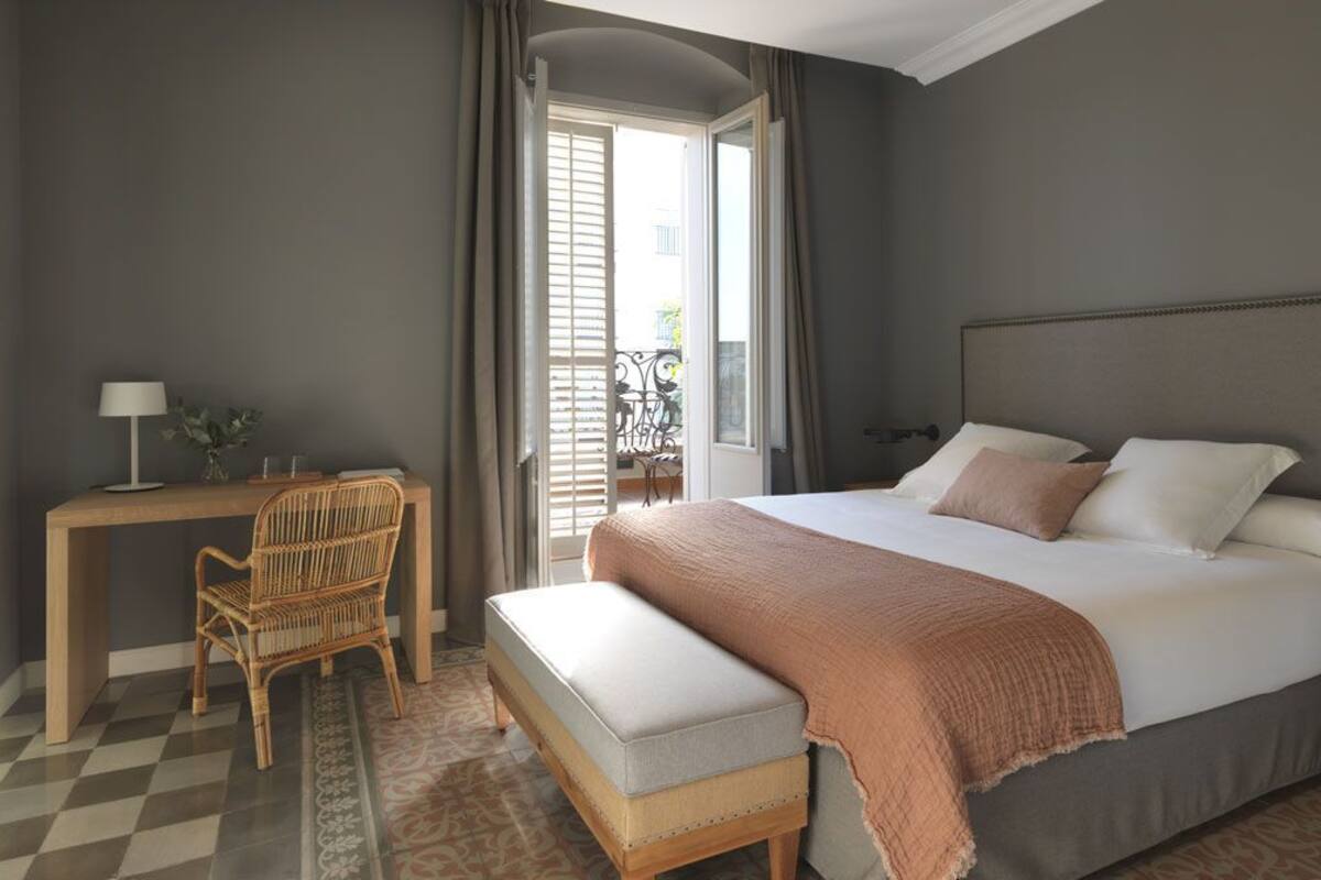 Une chambre à coucher avec un lit, un bureau, une chaise et une fenêtre.