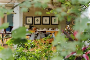 An indoor dining area with a table set for four, framed artwork on the wall, and a variety of tableware and condiments. - PheZulu Guest Lodge (Victoria Falls)