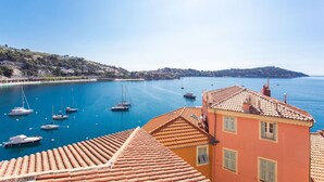A coastal town with a clear view of the sea, boats, and terracotta-roofed buildings. - LE BELVEDERE AP1059 by RIVIERA HOLIDAY HOMES (Villefranche-sur-Mer)