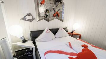 Ein Hotelzimmer mit einem Bett, zwei Nachttischlampen, einem Schreibtisch mit Lampe und einer Wanddekoration.