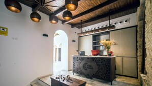 A modern kitchen with a central island, pendant lighting, and a stone wall. - Patios del Orfebre (Córdoba)