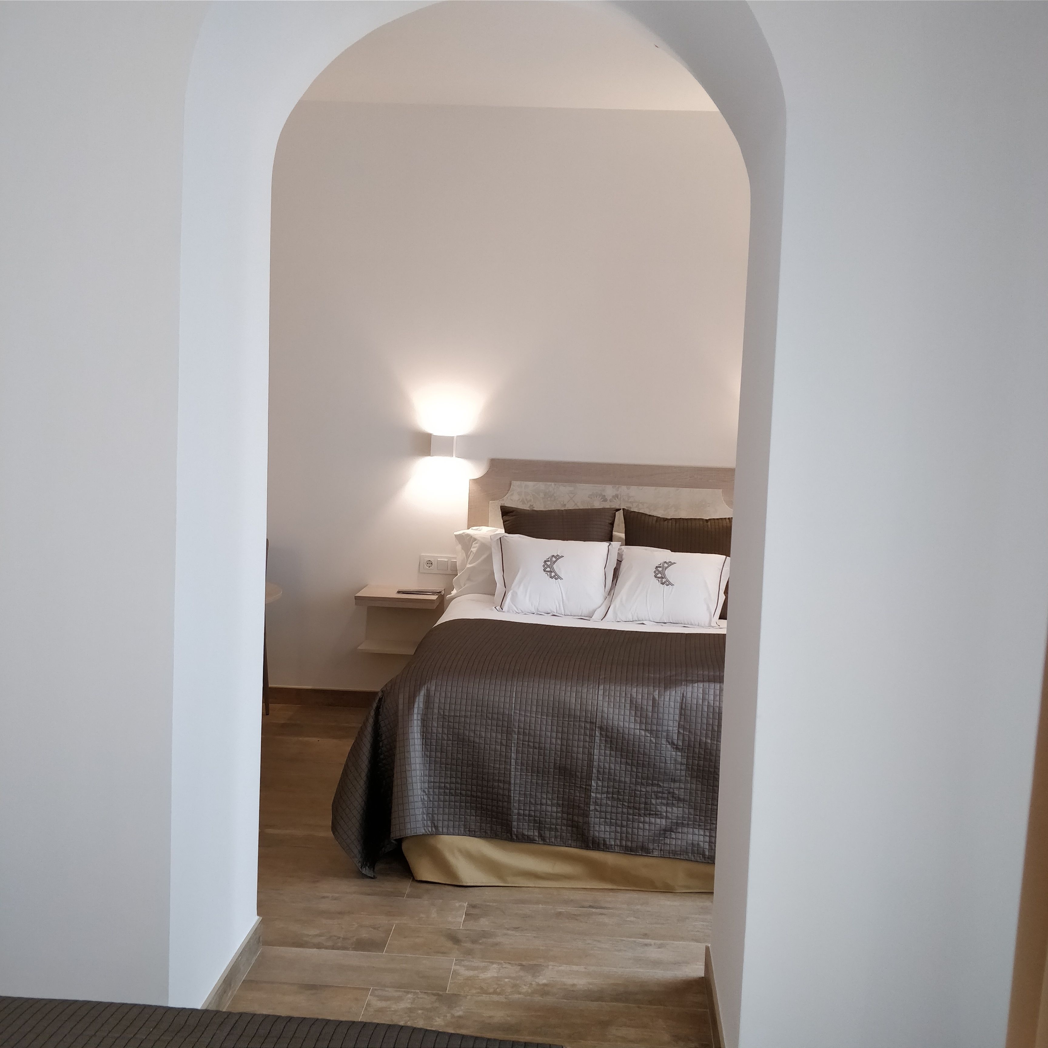 A bedroom with a bed, bedside table, and a nightstand.