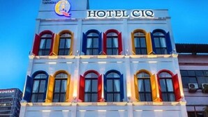 Un hotel de varios pisos con una fachada moderna, que cuenta con un logotipo destacado en la parte superior y un toldo rojo en la entrada.