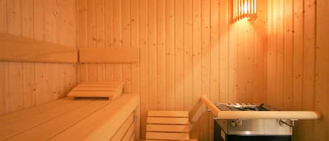 Una sauna de madera con bancos y un calentador.