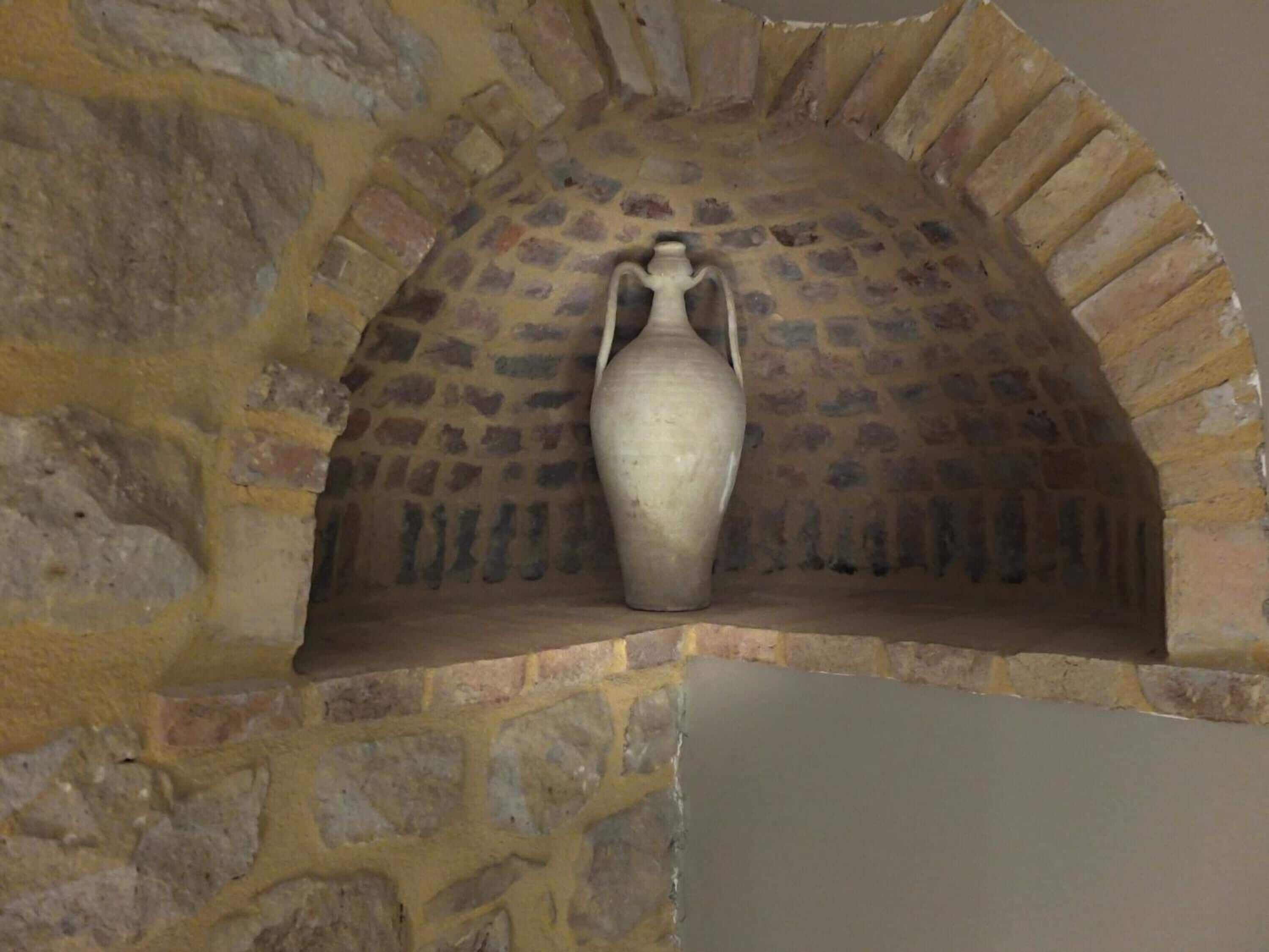 A stone oven with a large vase placed inside.